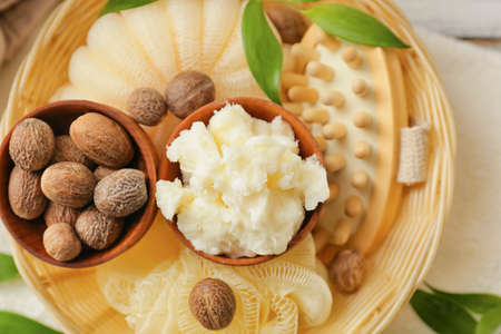 Basket with shea butter, nuts and bath supplies on table, closeupの写真素材