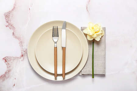 Beautiful table setting with narcissus flower on color background