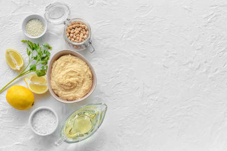 Composition with tasty hummus and ingredients on light backgroundの写真素材