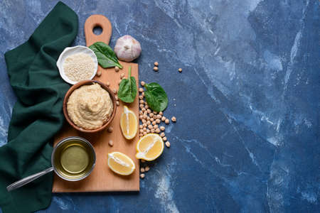 Composition with tasty hummus and ingredients on color backgroundの写真素材