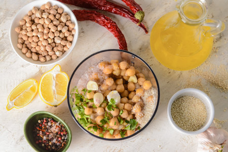 Blender with chickpea and ingredients for hummus on light backgroundの写真素材