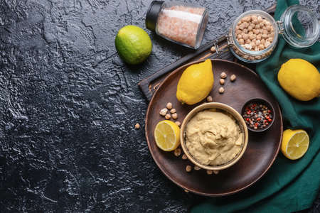 Composition with tasty hummus and ingredients on dark backgroundの写真素材