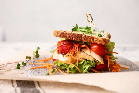 Board with tasty sandwich on light background, closeupの写真素材