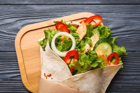 Board with tasty doner kebab on dark wooden backgroundの写真素材