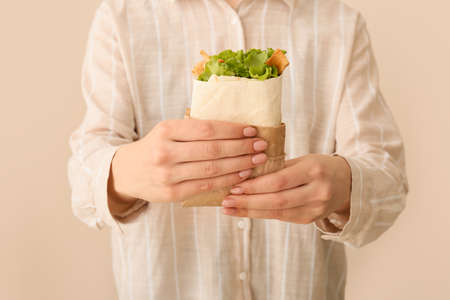 Woman with tasty doner kebab on color background, closeupの写真素材