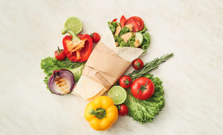 Tasty doner kebab and vegetables on light backgroundの写真素材