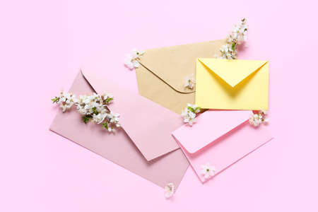 Beautiful blooming branches and envelopes on color backgroundの写真素材