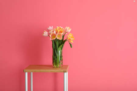 Bouquet of beautiful tulip flowers on table near color wallの写真素材
