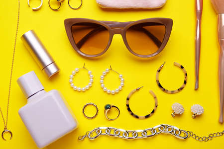 Set of female accessories and cosmetics on color background