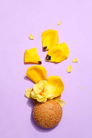Creative composition with burger and flowers on color backgroundの写真素材