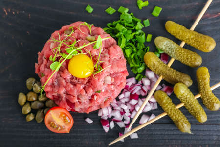 Tasty beef tartare on dark wooden background, closeupの写真素材