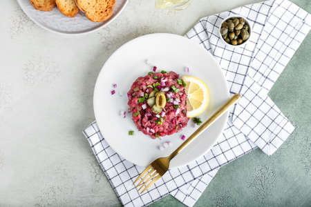 Plate with tasty beef tartare on light backgroundの写真素材