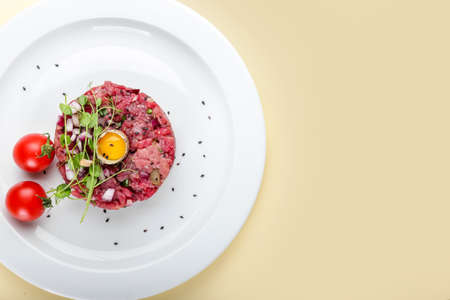 Plate with tasty beef tartare on color backgroundの写真素材