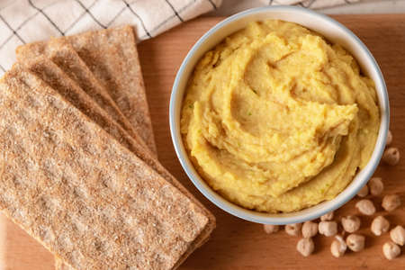 Bowl with tasty hummus, chickpeas and crackers on table, closeupの写真素材