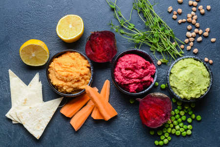 Composition with tasty hummus, lemon and pita on dark backgroundの写真素材