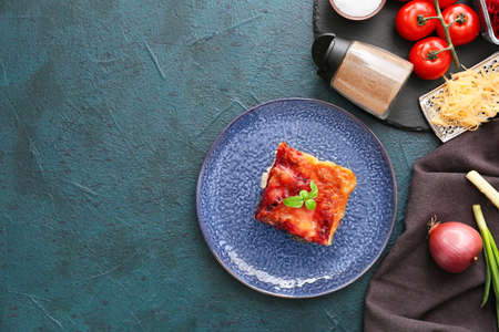 Composition with tasty vegetable lasagna and spices on dark background