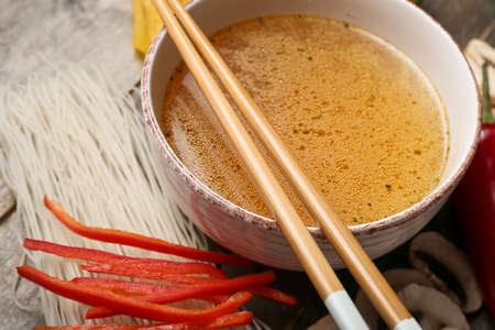 Bowl of tasty Thai soup and ingredients on table, closeupの写真素材