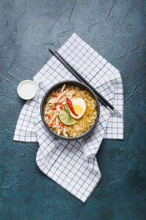 Bowl of tasty Thai soup with chicken on dark backgroundの写真素材