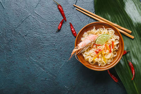 Bowl of tasty Thai soup with shrimps on dark backgroundの写真素材