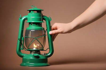 Hand and retro lamp on color backgroundの写真素材