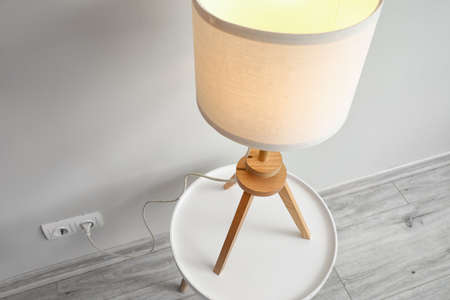 Stylish glowing lamp on table in roomの写真素材