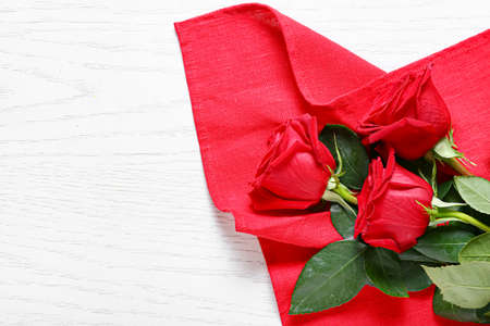 Beautiful roses and color fabric on white wooden backgroundの写真素材