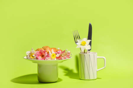 Creative composition with croissant and flowers on color background