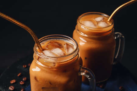 Mason jars with iced coffee on dark background, closeupの写真素材