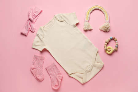 Set of baby clothes, socks and toy on color backgroundの写真素材