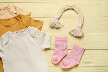 Baby clothes and socks on color wooden backgroundの写真素材