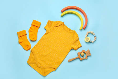 Set of baby clothes, socks and toy on color backgroundの写真素材