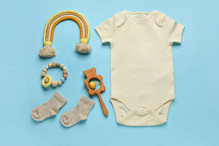 Set of baby clothes, socks and toys on color backgroundの写真素材