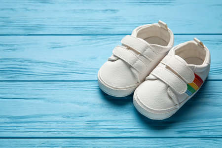 Stylish baby shoes on color wooden background, closeupの写真素材