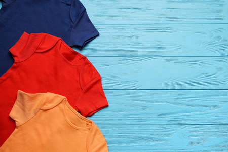 Baby clothes on color wooden backgroundの写真素材