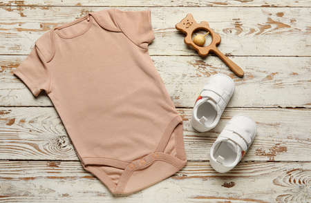 Baby clothes, shoes and toys on light wooden backgroundの写真素材