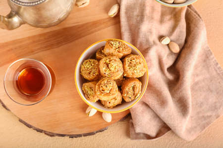 Bowl with delicious baklava and glass of Turkish tea on tableの写真素材