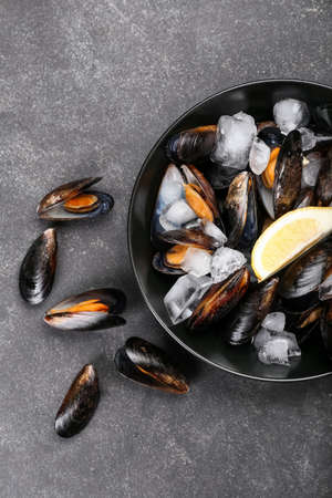 Plate with raw mussels on dark background, closeup