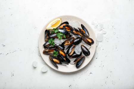 Plate with raw mussels on light backgroundの写真素材