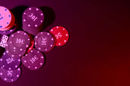 Poker chips and dices on dark background