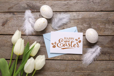 Easter greeting card, envelope, eggs and flowers on wooden backgroundの写真素材