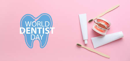 Model of jaw with dental braces, toothbrushes and paste on pink background. World Dentist Dayの写真素材