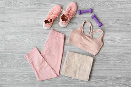 Sportswear, dumbbells, shoes and towels on light wooden backgroundの写真素材