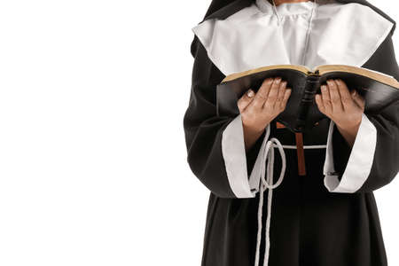 Mature nun with Holy Bible on white background