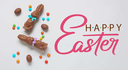 Easter greeting card with cute chocolate bunnies, eggs and candies