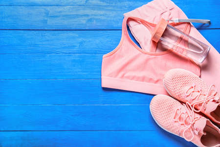 Sportswear, shoes and bottle for water on color wooden backgroundの写真素材