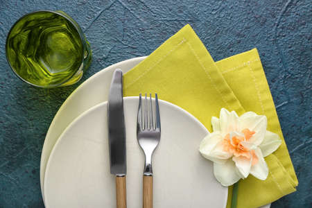 Beautiful table setting with narcissus flower on dark background