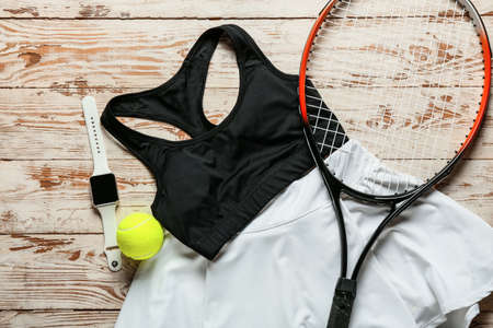 Sportswear, tennis racquet, ball and smartwatch on light wooden backgroundの写真素材