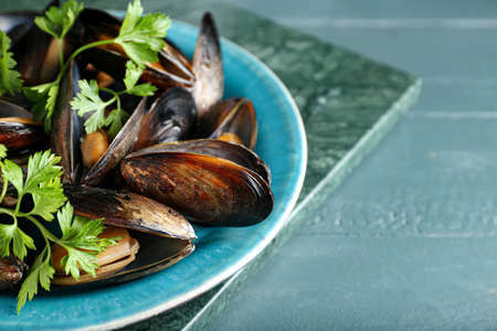 Plate with tasty mussels on color wooden background, closeupの写真素材
