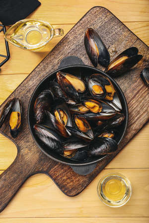 Frying pan with tasty mussels on wooden backgroundの写真素材