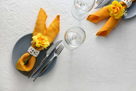 Beautiful table setting with narcissus flowers on white backgroundの写真素材